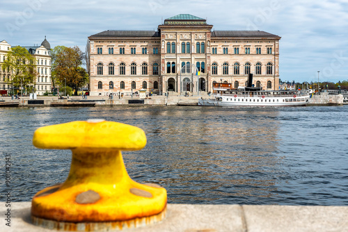 National Museum of Fine Arts (Nationalmuseum) building located on peninsula Blasieholmen in city centre with white boats, ships on Lake Malaren water, blue sky background, Stockholm, Sweden photo