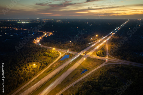 Wide multilane highway crossroads in Florida, USA with fast driving cars at sunset. Above view of American transportation infrastructure