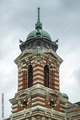 New York, NY, USA - August 4, 2023: One of Ellis Island National Museum of Immigration corner towers agasomt gray sky photo