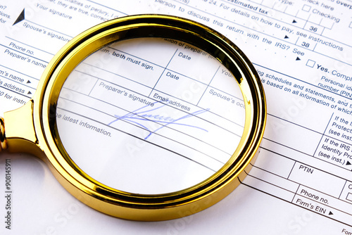 Signature on a document and a magnifying glass, concept of forensic handwriting examination of a signature photo
