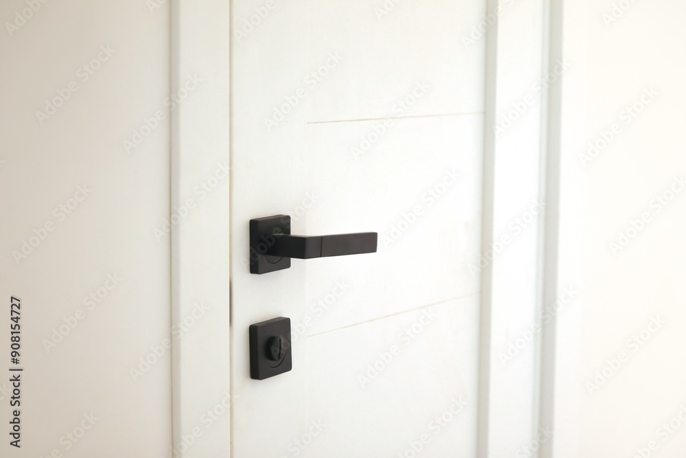 Minimalist white door with black handle and lock against a clean wall, perfect for modern interior design, architectural magazines, or home renovation projects Minimalist white door with black handle and lock against a clean wall, perfect for modern interior design, architectural magazines, or home renovation projects