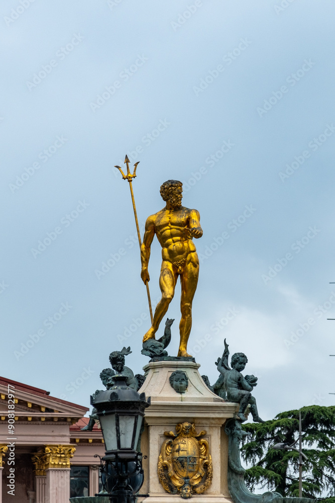 Obraz premium Batumi, Georgia, 07.30.2024: Golden statue of Poseidon, the Greek god of the sea, prominently displayed in Batumi, Georgia, against a clear sky backdrop