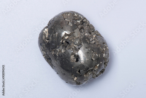 Fotografie Close up studio photo of a tumbled pyrite stone on white background
