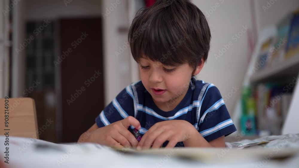 Young boy intently focusing on a small toy or puzzle while sitting on his bed in a child’s room, demonstrating concentration and engagement Young boy intently focusing on a small toy or puzzle while sitting on his bed in a child’s room, demonstrating concentration and engagement