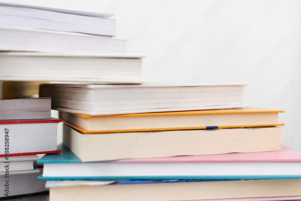Stack of books with colorful bookbindings against white wall with copy space, book lover Stack of books with colorful bookbindings against white wall with copy space, book lover