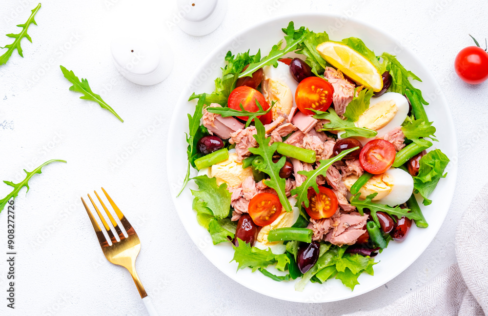 Tasty salad with tuna, tomatoes, eggs, beans, lettuce and olives on white background, top view
