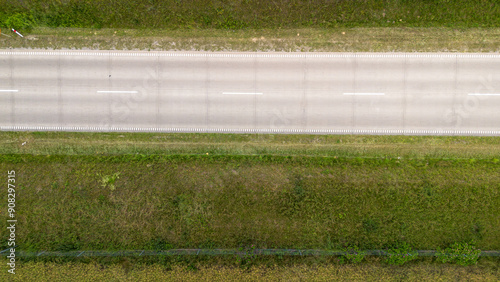 Aerial View of a Straight Rural Road Surrounded by Green Grass and Vegetation