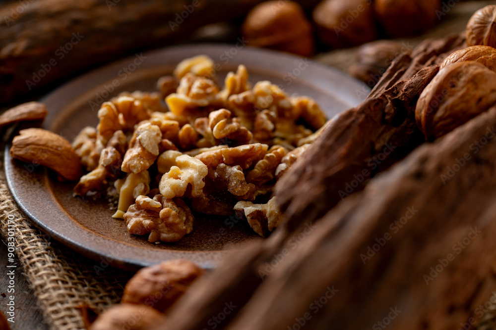 Obraz premium Walnut kernels and whole walnuts on a table. Image of organic walnuts.