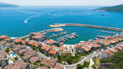 Aerial view of Lustica Bay, a new luxury resort along the coast of the Adriatic Sea in Montenegro - Exclusive marina for private yachts with a jetty ended by a lighthouse in the Mediterranean photo