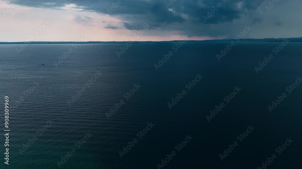 Aerial shot of a big thunderstorm on a lake. Big dark clouds gather over Lake Garda. 4k stock footage. Climate emergency, global warming. Aerial shot of a big thunderstorm on a lake. Big dark clouds gather over Lake Garda. 4k stock footage. Climate emergency, global warming.