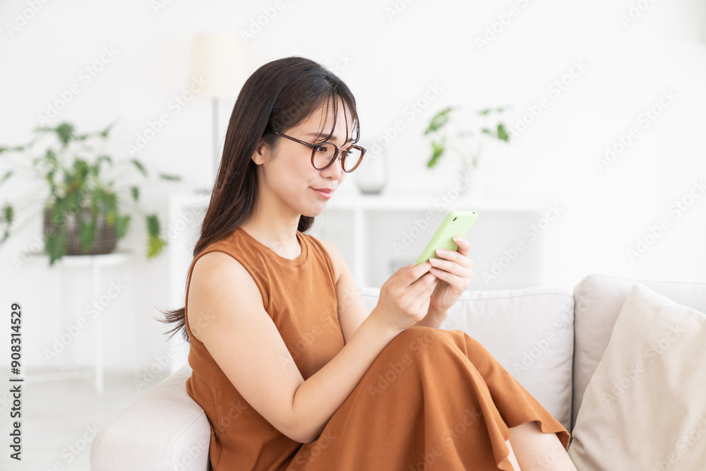 部屋でスマホを見る若い女性 部屋でスマホを見る若い女性