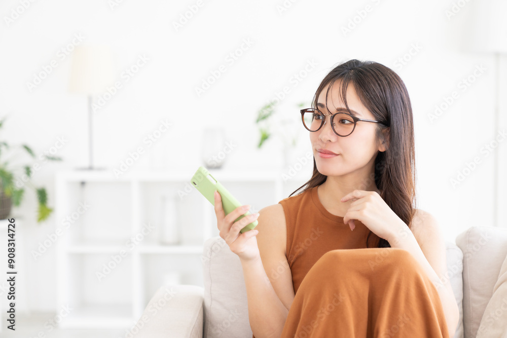 部屋でスマホを見る若い女性 部屋でスマホを見る若い女性