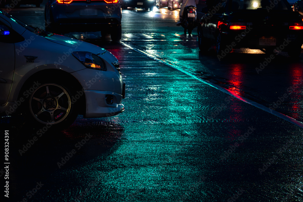 A car is parked on a wet street at night A car is parked on a wet street at night
