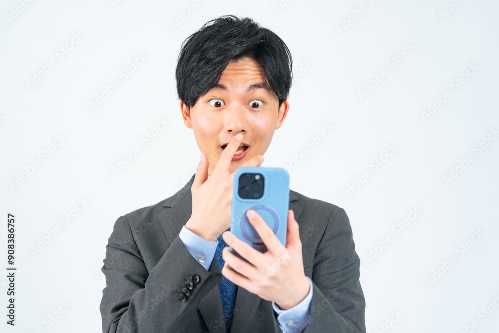 スマホを見て驚く男性ビジネスパーソン