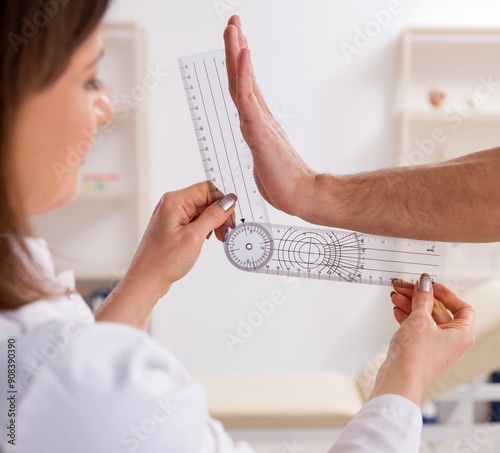 Female doctor checking patient's joint flexibility with goniomet photo