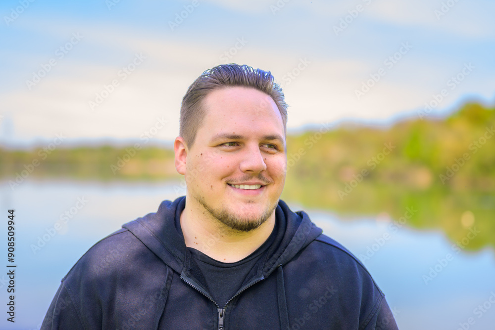Smiling Young Man Outdoors by the Lake Smiling Young Man Outdoors by the Lake
