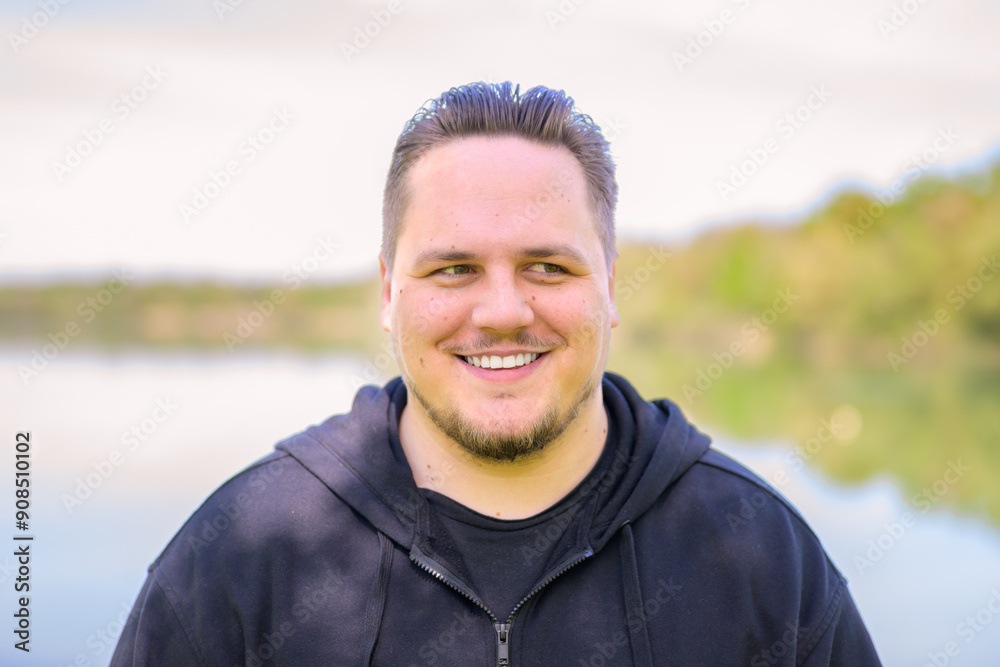 Smiling Young Man Outdoors by the Lake Smiling Young Man Outdoors by the Lake