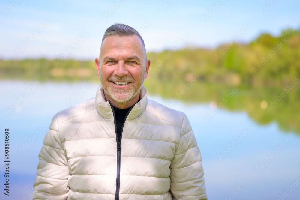 Middle-Aged Man Smiling by a Serene Lake Middle-Aged Man Smiling by a Serene Lake