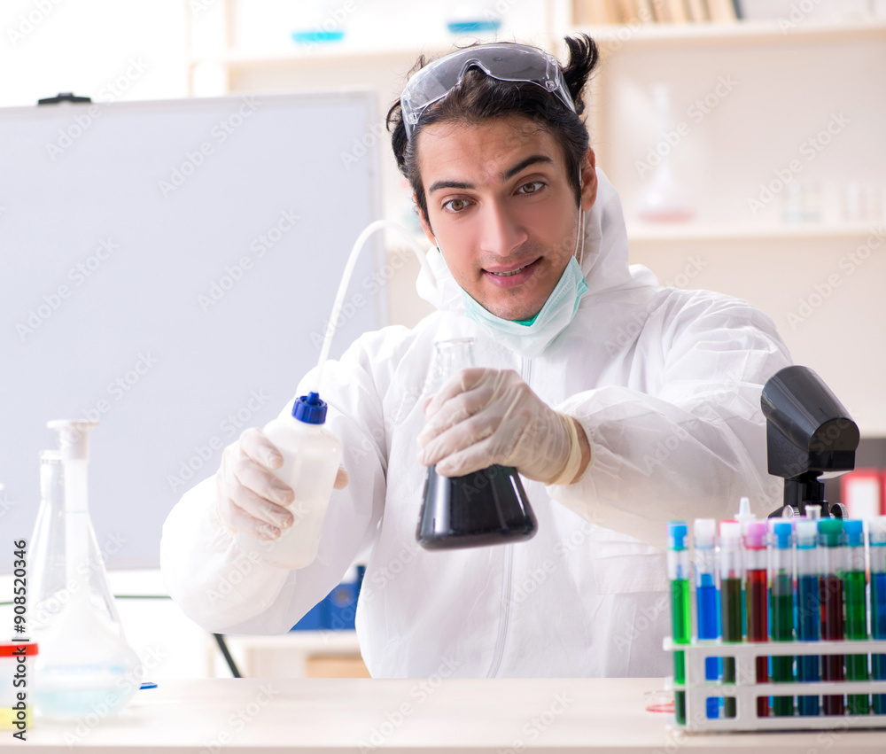 Naklejka premium Young handsome chemist working in the lab
