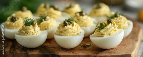 Footballshaped deviled eggs with tangy dill and capers, displayed on a chic and modern serving board