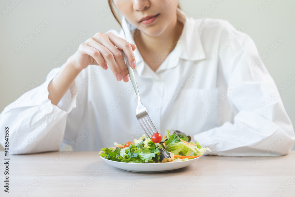 Diet in bored face, unhappy beautiful asian young woman, girl on dieting, holding fork at tomato on salad plate, dislike or tired with eat fresh vegetables. Nutrition of clean, healthy food good taste Diet in bored face, unhappy beautiful asian young woman, girl on dieting, holding fork at tomato on salad plate, dislike or tired with eat fresh vegetables. Nutrition of clean, healthy food good taste