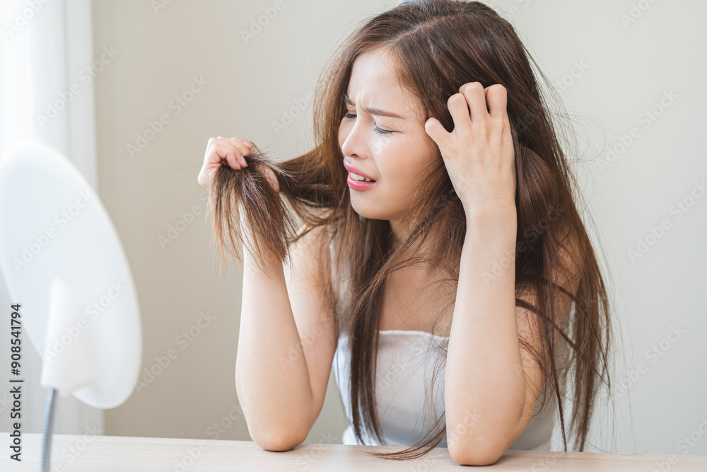 Damaged Hair, frustrated asian young woman, girl hand in holding splitting ends, messy unbrushed dry hair with face shock, long disheveled hair, health care of beauty. Portrait isolated on background. Damaged Hair, frustrated asian young woman, girl hand in holding splitting ends, messy unbrushed dry hair with face shock, long disheveled hair, health care of beauty. Portrait isolated on background.