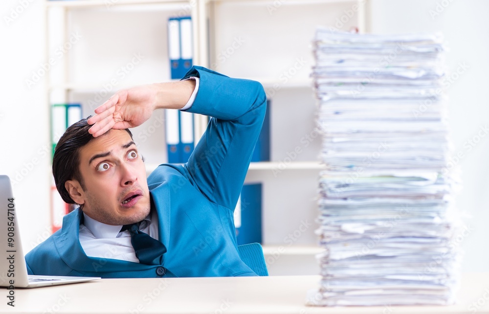 Young male employee unhappy with excessive work Young male employee unhappy with excessive work