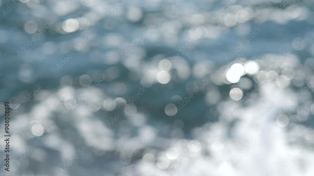 Sea view on a sunny summer day. Seascape. Sea landscape with blue sea water surface, small ripples and white bokeh spots with highlights of reflecting of the sun. Blurred abstract natural background