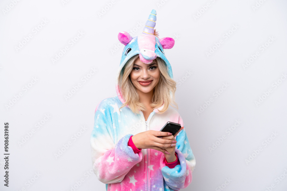 Young Russian woman with unicorn pajamas isolated on white background sending a message with the mobile Young Russian woman with unicorn pajamas isolated on white background sending a message with the mobile