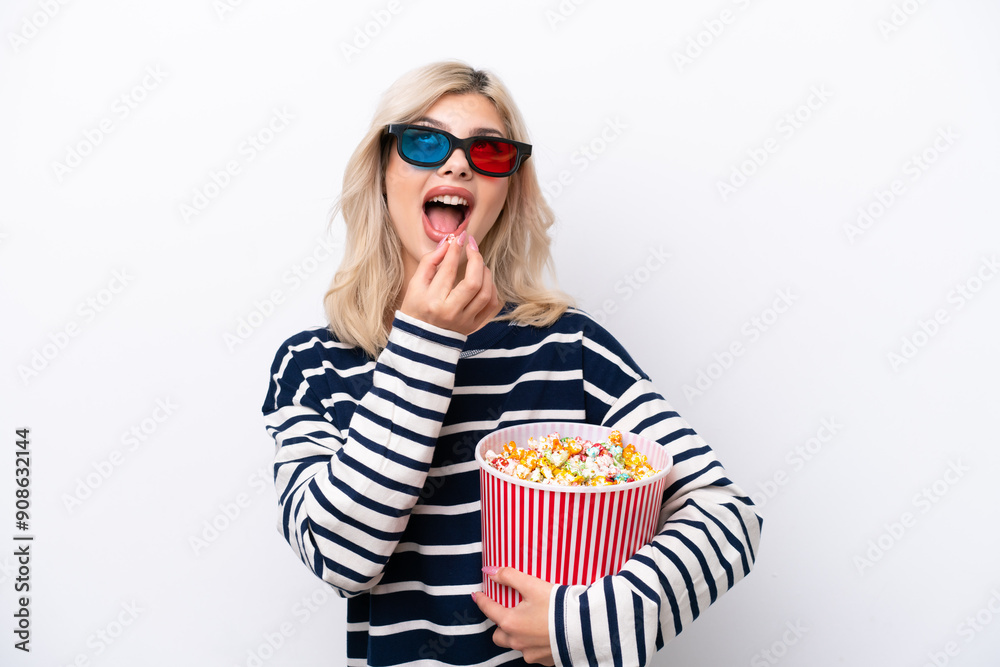 Obraz premium Young Russian woman isolated on white background with 3d glasses and holding a big bucket of popcorns