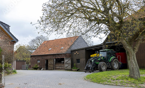 view of a large farm villa with a tractor and barn
