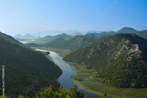 
Observation deck Pavlova Strana in Montenegro. The mountain is surrounded by the Crnojevica River. Mountain range covered with green forest, clear blue sky.