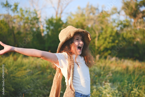 A Joyful Girl in Nature Wearing a Hat and Smiling Radiantly in the Beautiful Outdoors