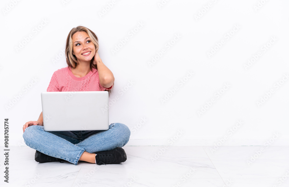 Young Russian girl with a laptop sitting on the floor isolated on white background thinking an idea Young Russian girl with a laptop sitting on the floor isolated on white background thinking an idea