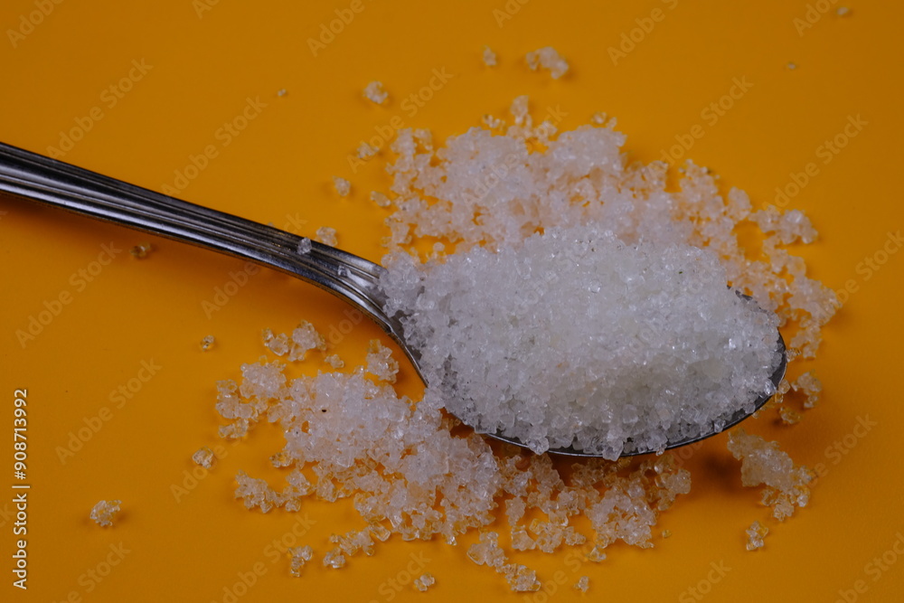 granulated sugar in a spoon. natural sweetener made from sugar cane juice. spoonful of sugar. granulated sugar in a spoon. natural sweetener made from sugar cane juice. spoonful of sugar.