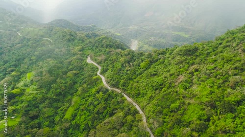 Mountains covered with jungle and a waterfall in the distance, aerial view. photo