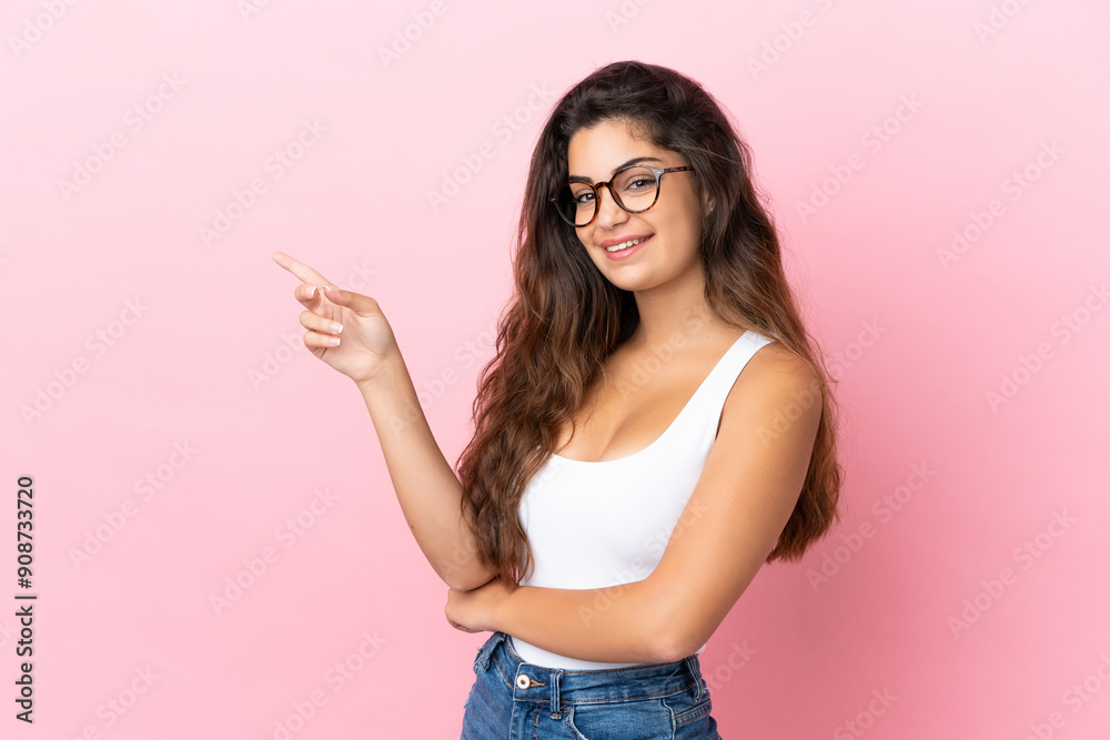 Young caucasian woman isolated on pink background pointing finger to the side Young caucasian woman isolated on pink background pointing finger to the side