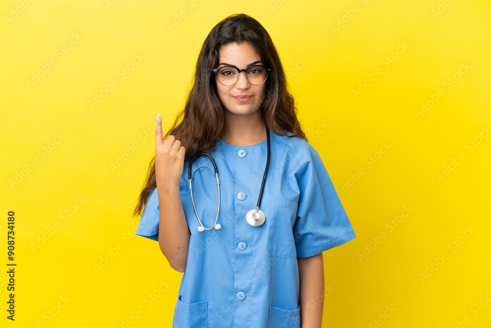 Young surgeon doctor woman isolated on yellow background pointing with the index finger a great idea Young surgeon doctor woman isolated on yellow background pointing with the index finger a great idea