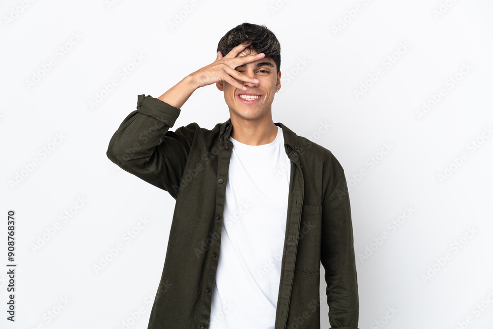 Young man over isolated white background covering eyes by hands and smiling Young man over isolated white background covering eyes by hands and smiling