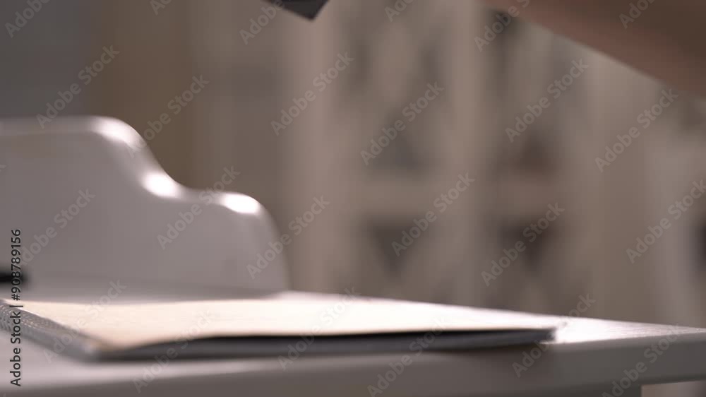 Woman applies stamp onto cover of craft spiral notepad at table closeup. Female office worker marks recyclable notebook. Paperwork job Woman applies stamp onto cover of craft spiral notepad at table closeup. Female office worker marks recyclable notebook. Paperwork job