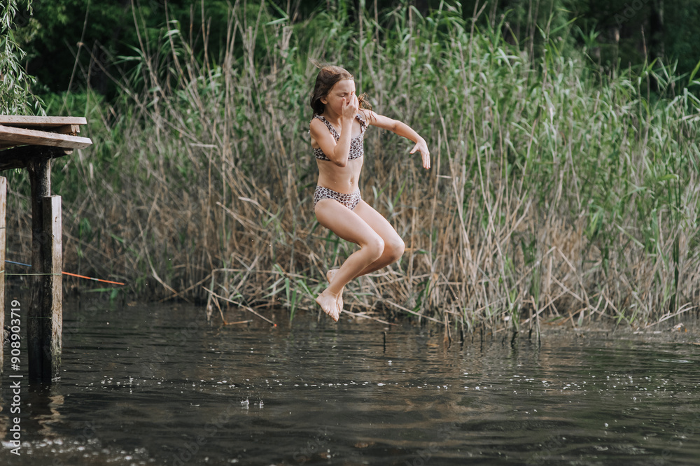 Athletic beautiful teenage girl, child jumping from a wooden bridge, pier into the water outdoors in nature. Photography, portrait, childhood concept, sport. Athletic beautiful teenage girl, child jumping from a wooden bridge, pier into the water outdoors in nature. Photography, portrait, childhood concept, sport.