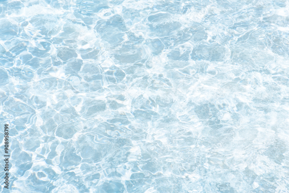 Obraz premium Blue water with ripples on the surface. Defocus blurred transparent blue colored clear calm water surface texture with splashes and bubbles. Water waves with shining pattern texture background.