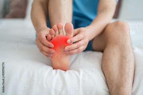 Foot pain, corns and calluses, dry skin on legs, man suffering from feet ache at home