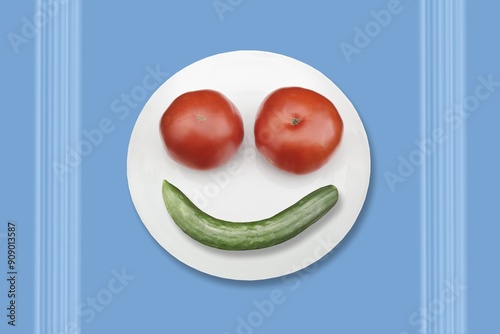 Two tomatoes and a cucumber on a plate in the shape of a smiling face.