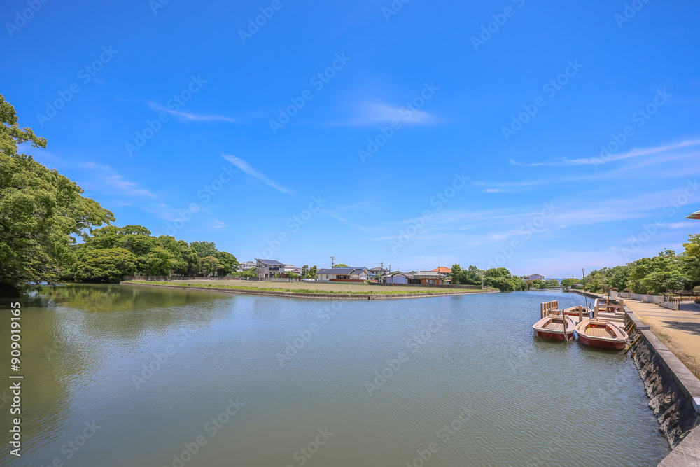 Fototapeta premium May 17 2024 poled boat, parked at deck in Yanagawa with green willow leaves