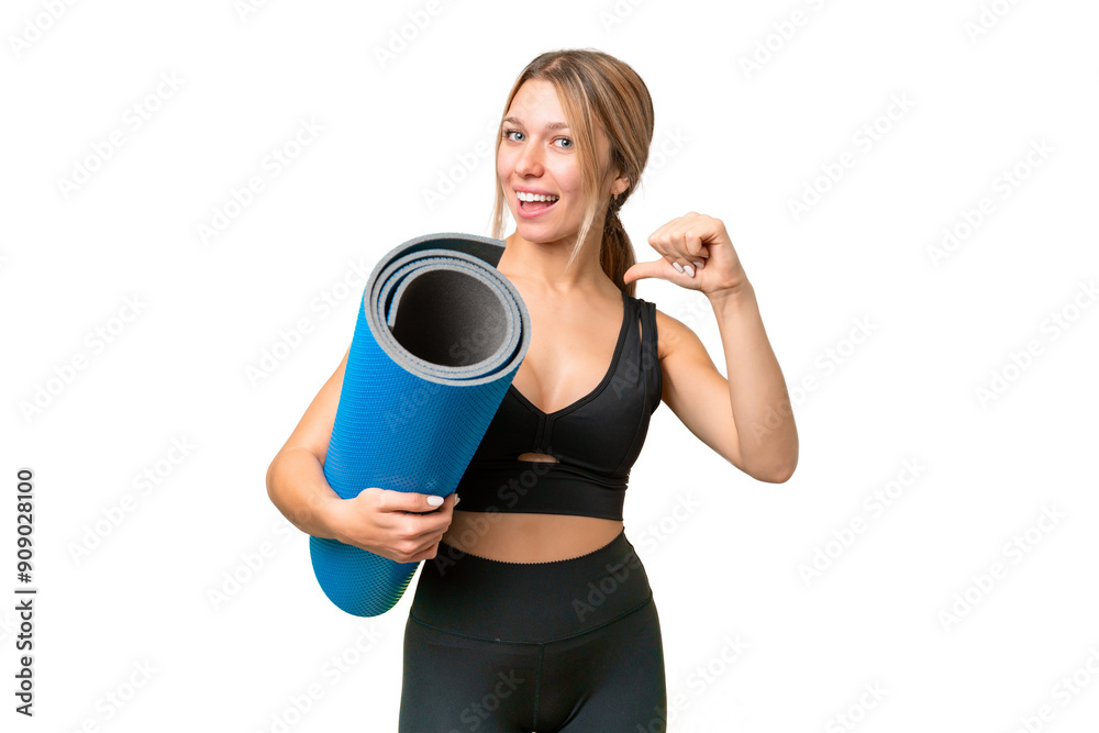 Blonde sport woman going to yoga classes while holding a mat over isolated chroma key background proud and self-satisfied