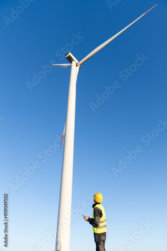 Engineer with digital tablet controls wind turbines