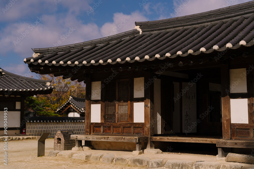 the traditional Korean architecture at Gyeonggijeon Shrine, featuring wooden beams, a tiled roof, and white walls under a clear blue sky. the traditional Korean architecture at Gyeonggijeon Shrine, featuring wooden beams, a tiled roof, and white walls under a clear blue sky.