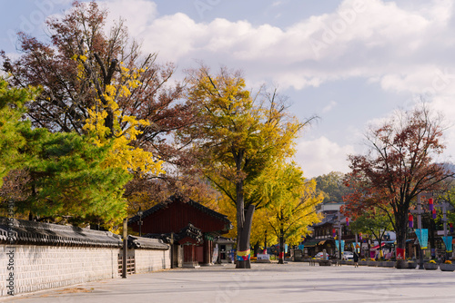 the traditional Korean architecture at Gyeonggijeon Shrine, featuring wooden beams, a tiled roof, and white walls under a clear blue sky. photo