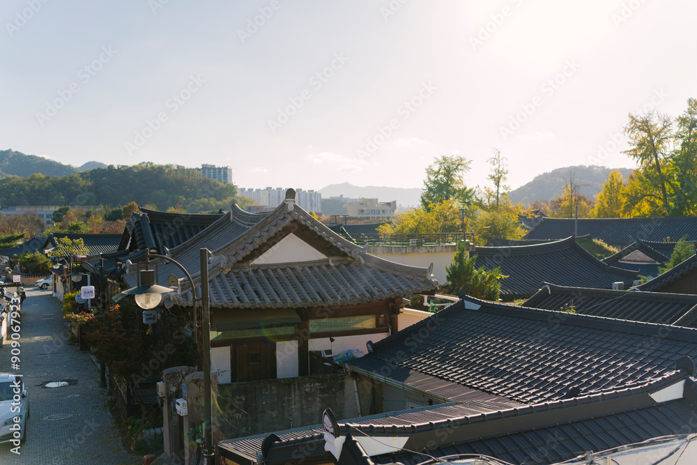 a traditional Korean village with distinct Asian-style tiled roofs, nestled among modern buildings under a clear sky, highlighting the contrast between historical and contemporary architecture. a traditional Korean village with distinct Asian-style tiled roofs, nestled among modern buildings under a clear sky, highlighting the contrast between historical and contemporary architecture.